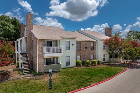 A two-story house with a red trim around the windows and a red trim around the roof.