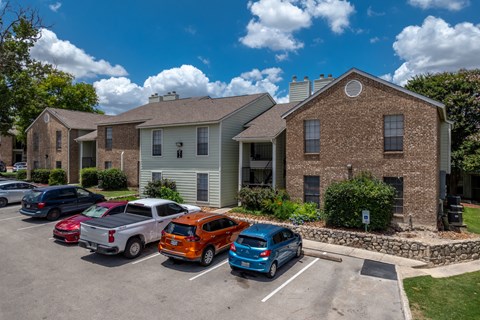 A parking lot with cars and a building in the background.