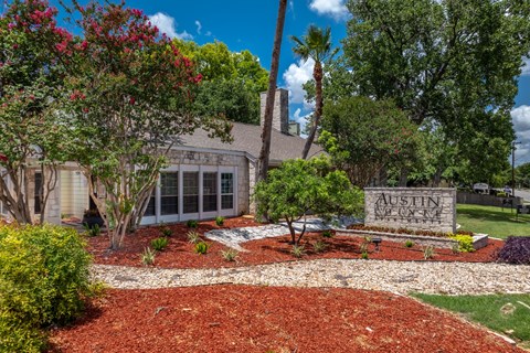A sign that says "Austin" is in front of a house.
