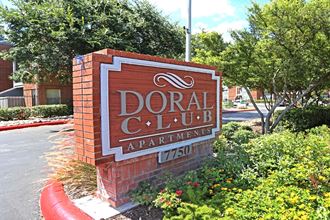 a sign for doral condo apartments in front of a street