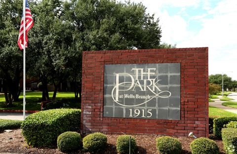 the sign for the park in front of the flag