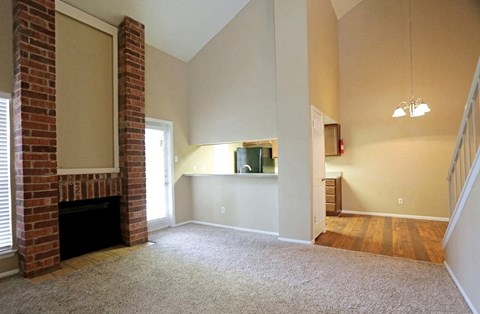 an empty living room with a brick fireplace