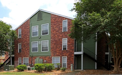 an apartment building with a brick and green facade