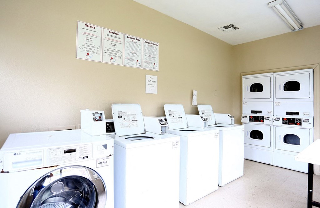 a laundry room filled with lots of coin washing machines