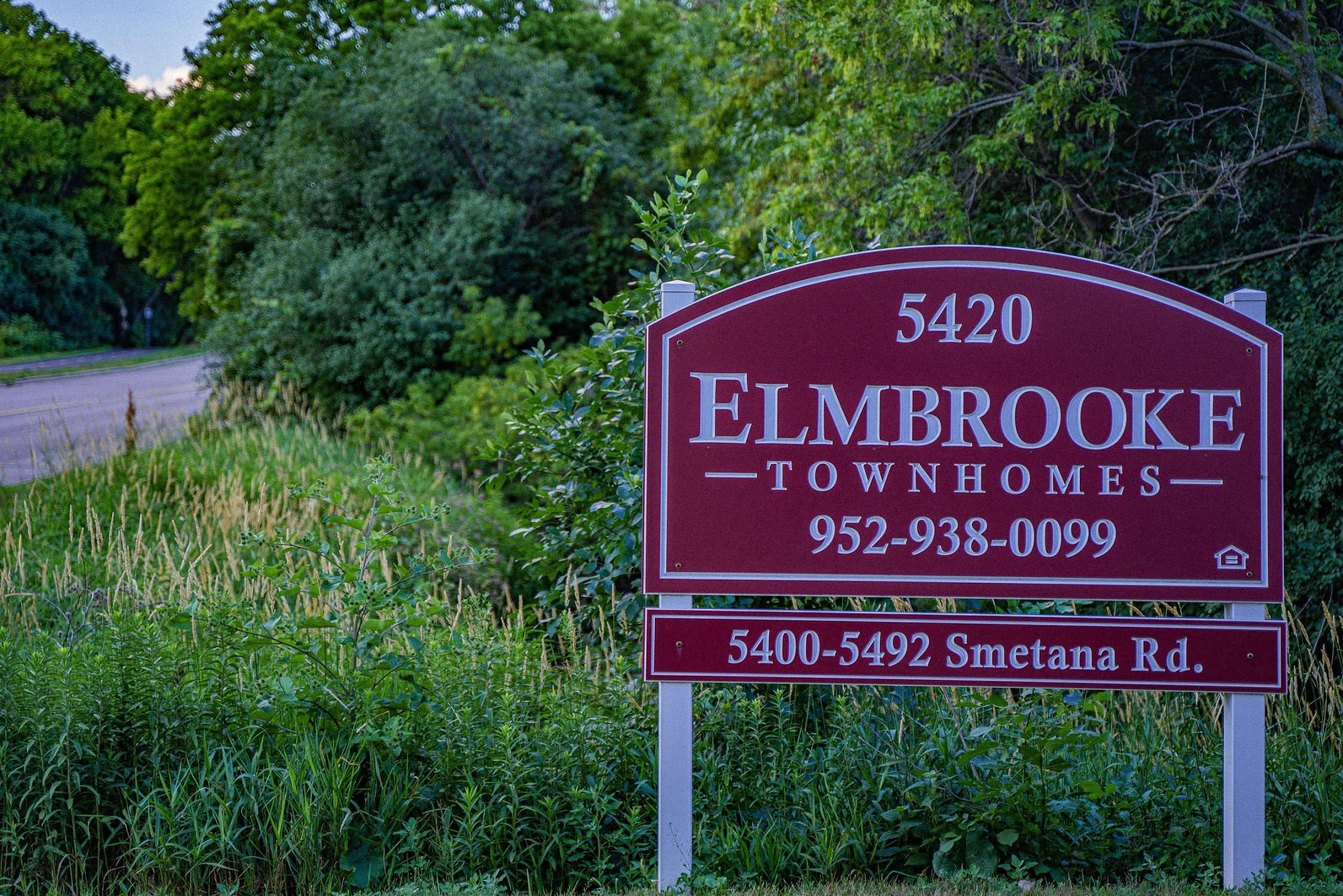 a sign that reads elmbrook townhomes in front of a road