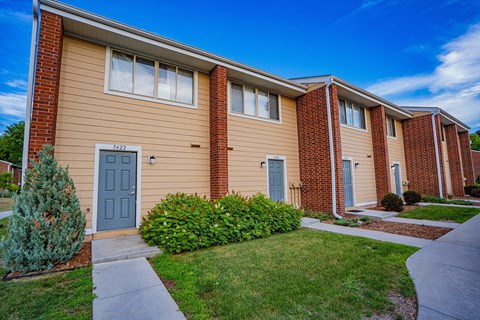 a sidewalk in front of a building with a blue door