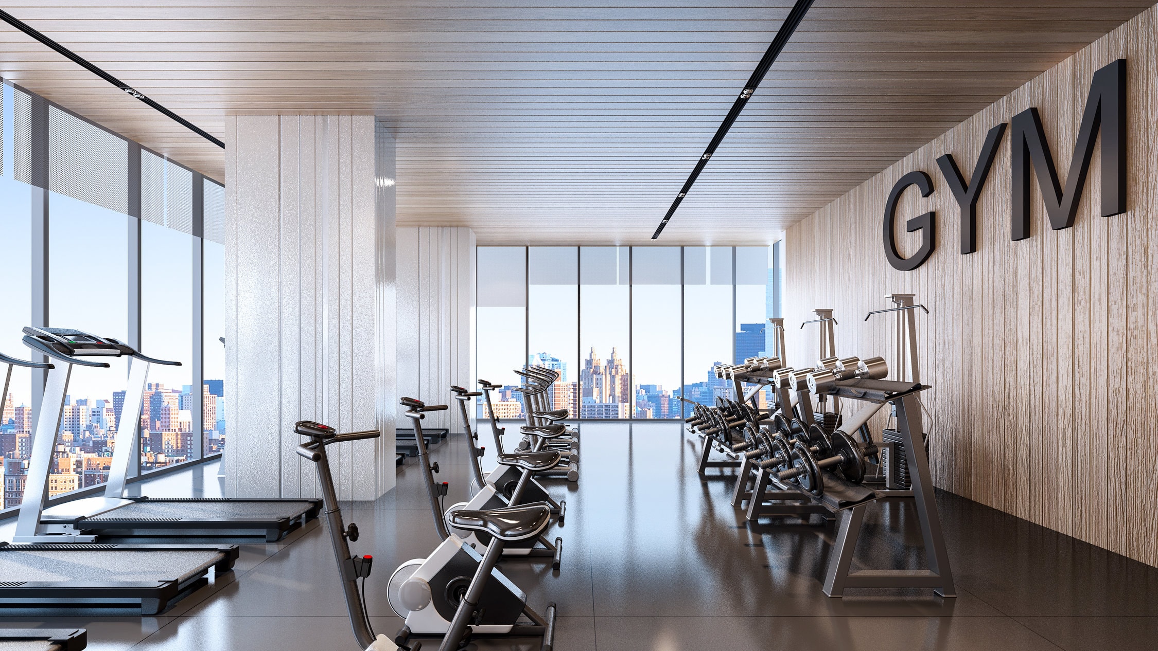 a gym with floor to ceiling windows and a wall of gym equipment