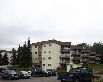 a parking lot full of cars in front of an apartment building