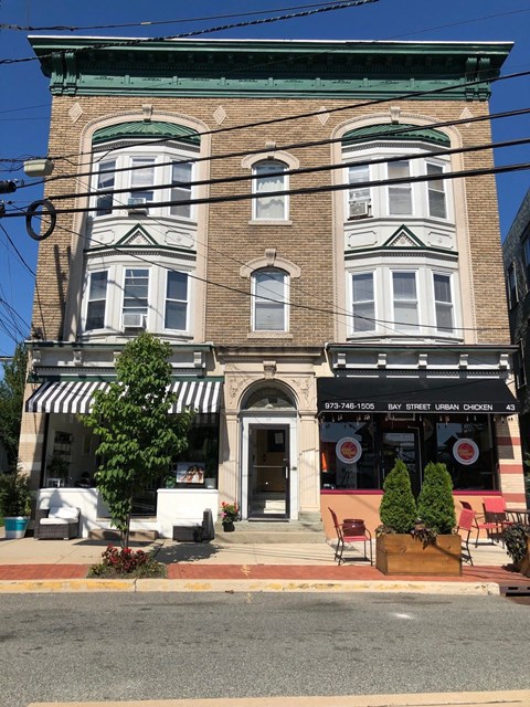 A building with a striped awning and a sign that says Urban Chicken.