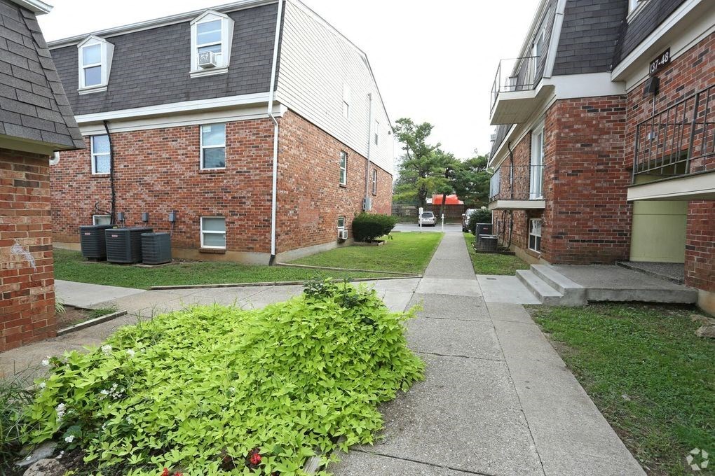 an empty sidewalk in front of an apartment building