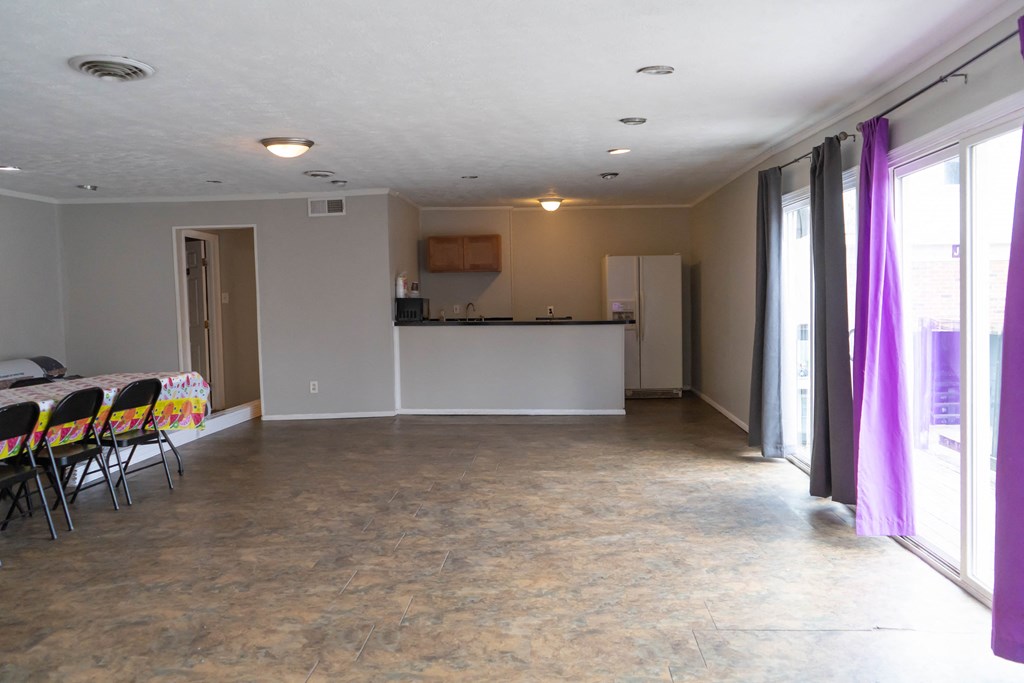 an empty living room with a dining room and a kitchen