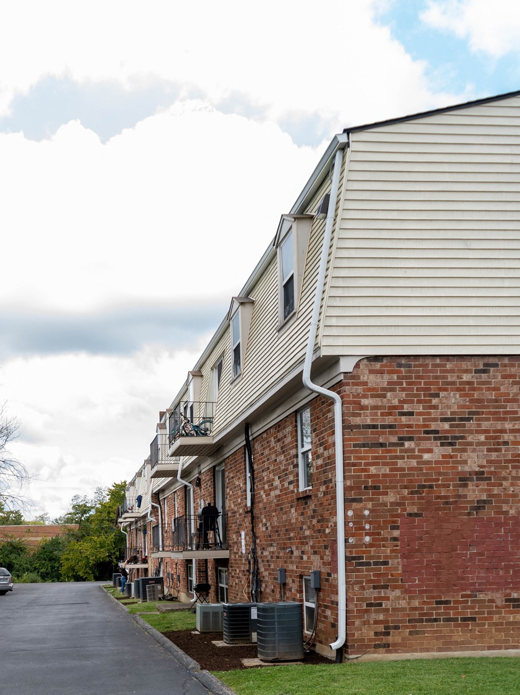 the side of a brick apartment building with a street in front