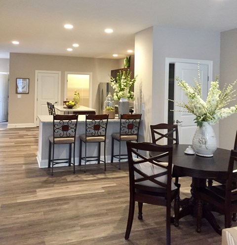 a dining room and kitchen with a table and chairs