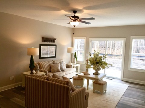 a living room with couches and a ceiling fan