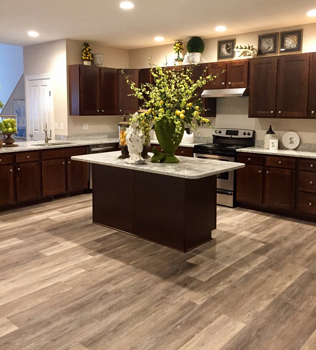 a kitchen with a center island and a vase of flowers