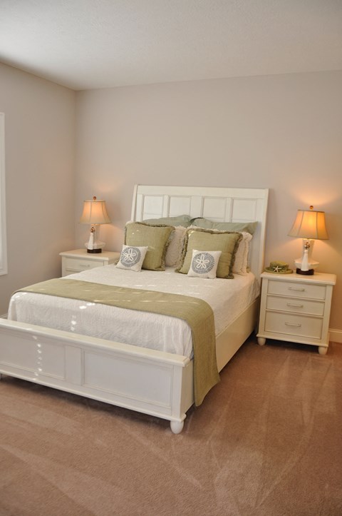 a bedroom with a bed and two night stands with lamps