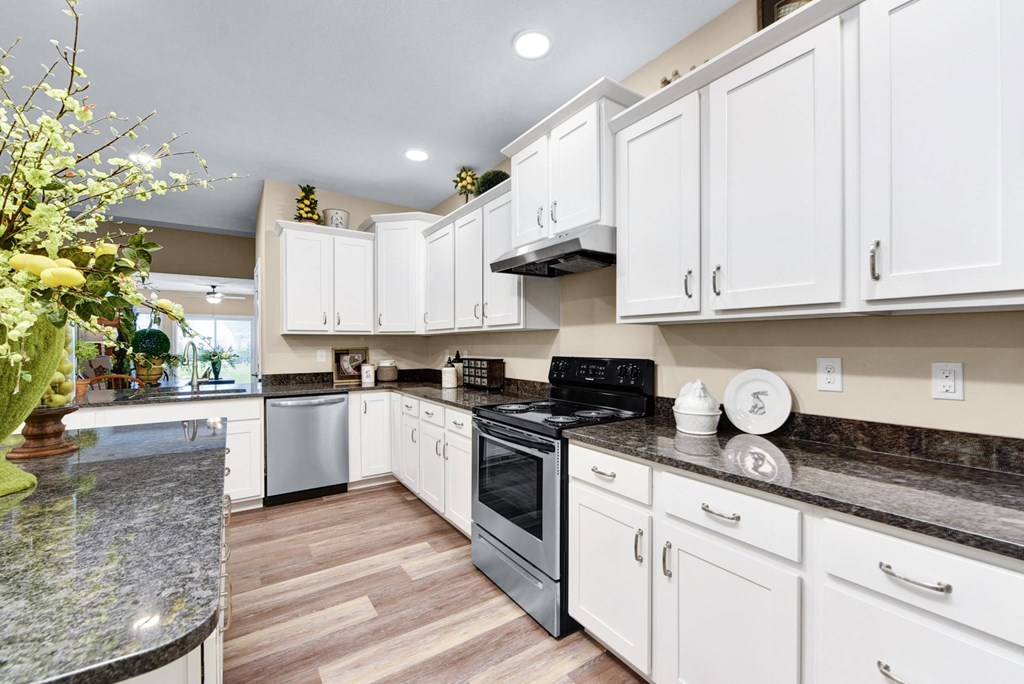 a kitchen with white cabinets and black appliances