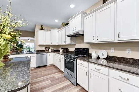 a kitchen with white cabinets and black appliances