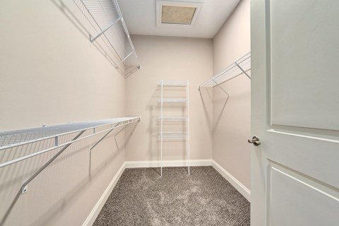 a spacious closet with white walls and a ladder in the corner