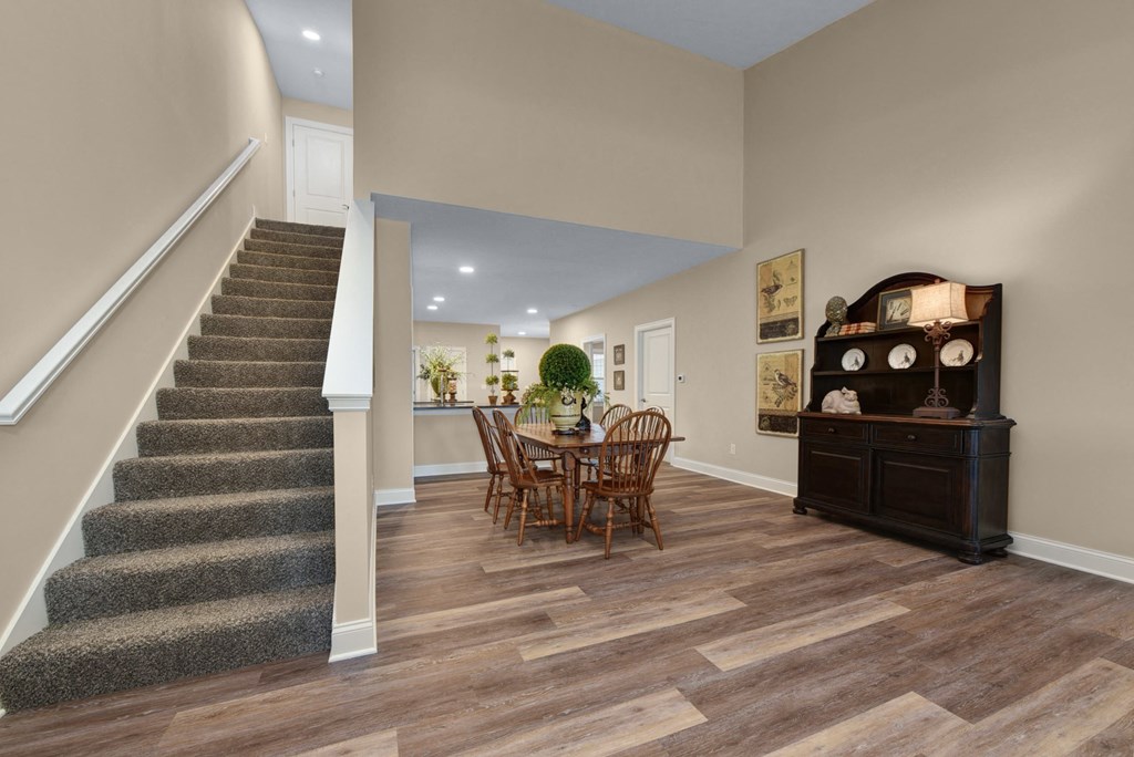 a dining room with a table and chairs next to a staircase