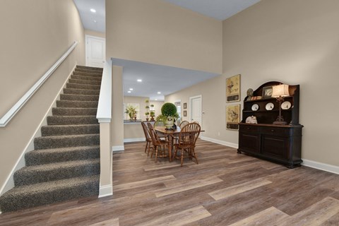 a dining room with a table and chairs next to a staircase