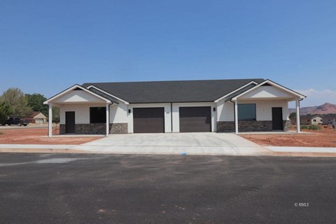 a single story home with two garage doors and a driveway