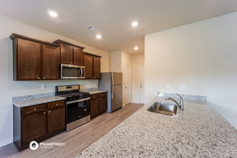 the kitchen with granite countertops and stainless steel appliances