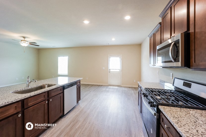 an empty kitchen with granite counter tops and stainless steel appliances