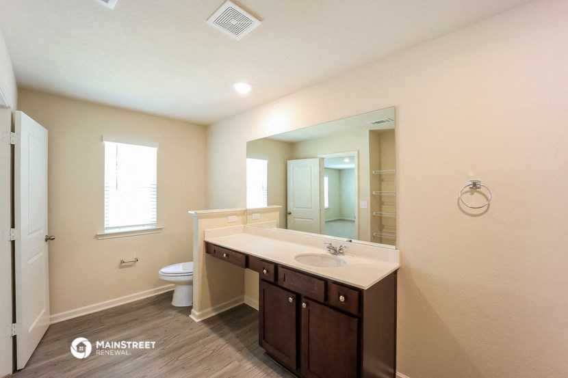 a bathroom with a large mirror and a sink and a toilet
