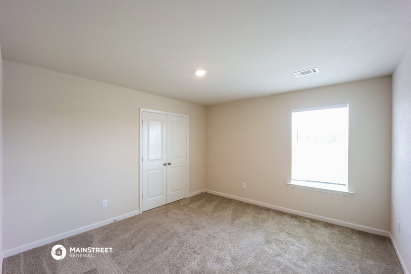 a room with carpet and a door and a window