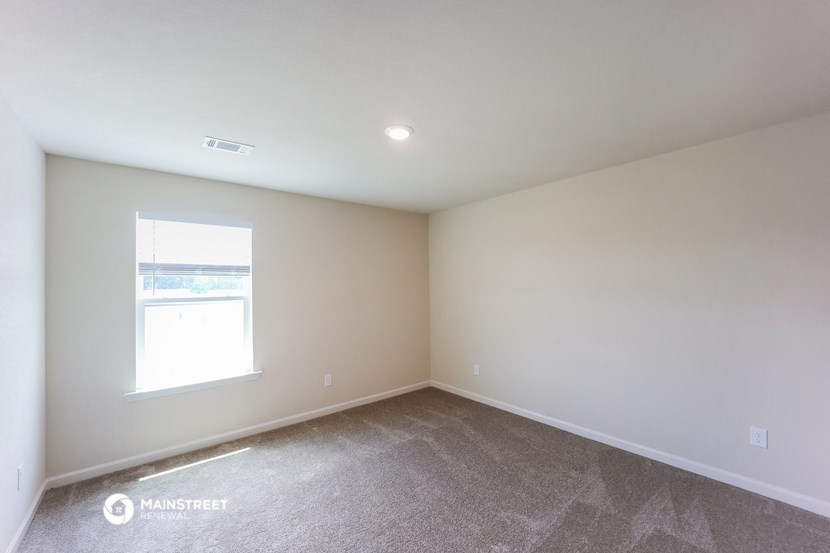 an empty room with carpet and a window