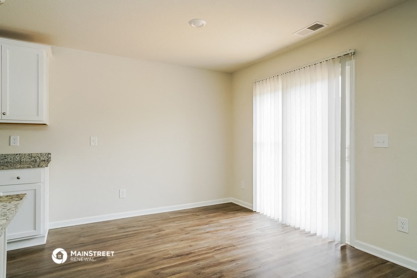 an empty living room with white walls and wood floors