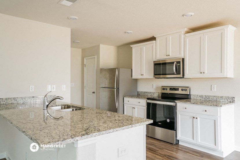 a kitchen with white cabinets and granite counter tops