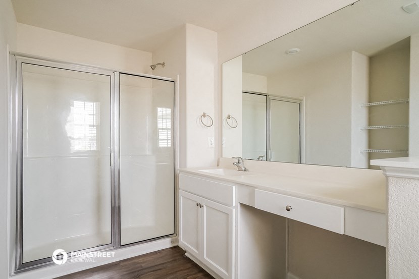 a bathroom with a shower and a sink and a mirror