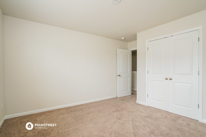 a bedroom with two closets and a door to a hallway