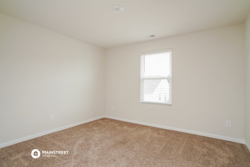 the living room of a home with carpet and a window
