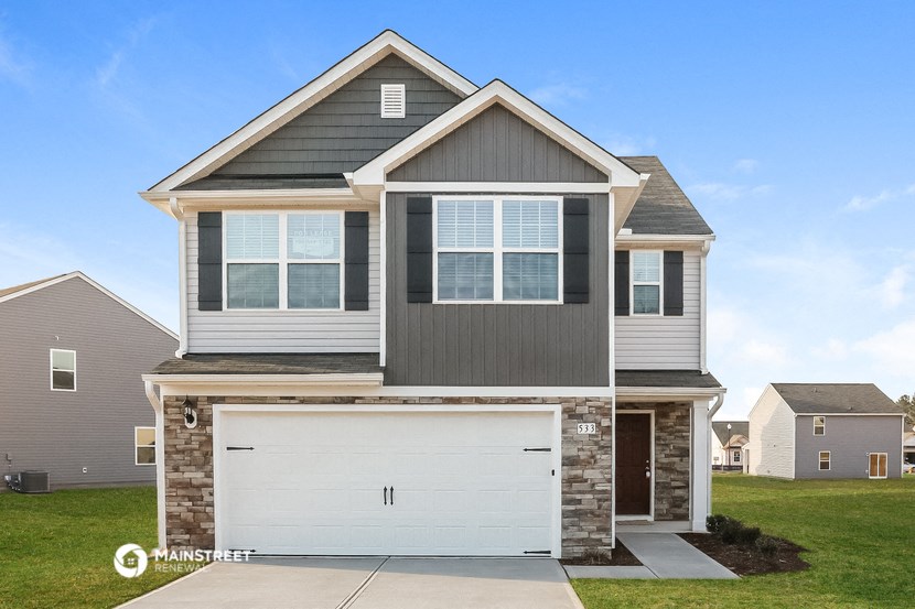 a house with a white garage door in front of a lawn