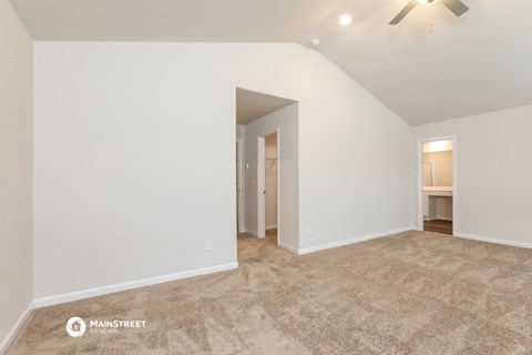 the living room and dining room with white walls and carpet