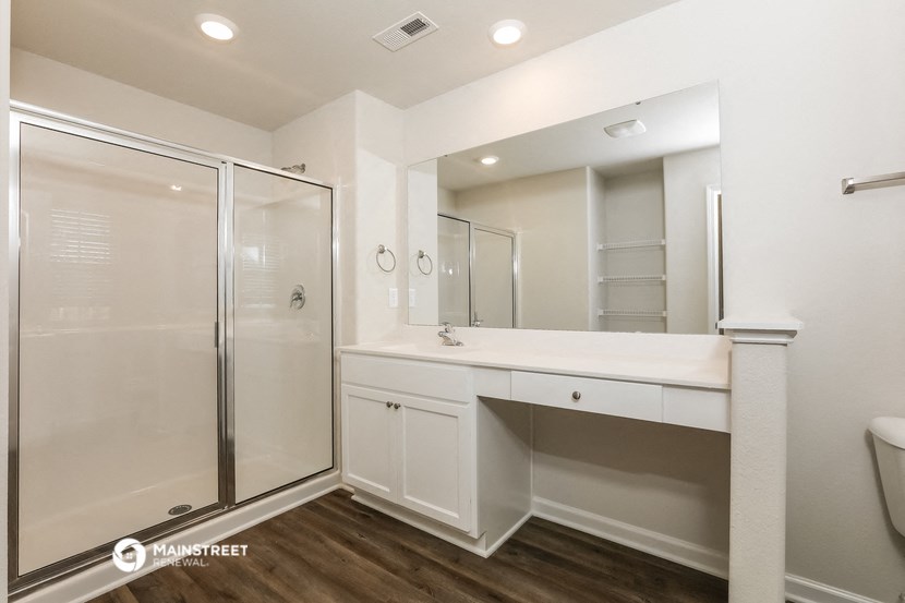a bathroom with a shower and a sink and a mirror