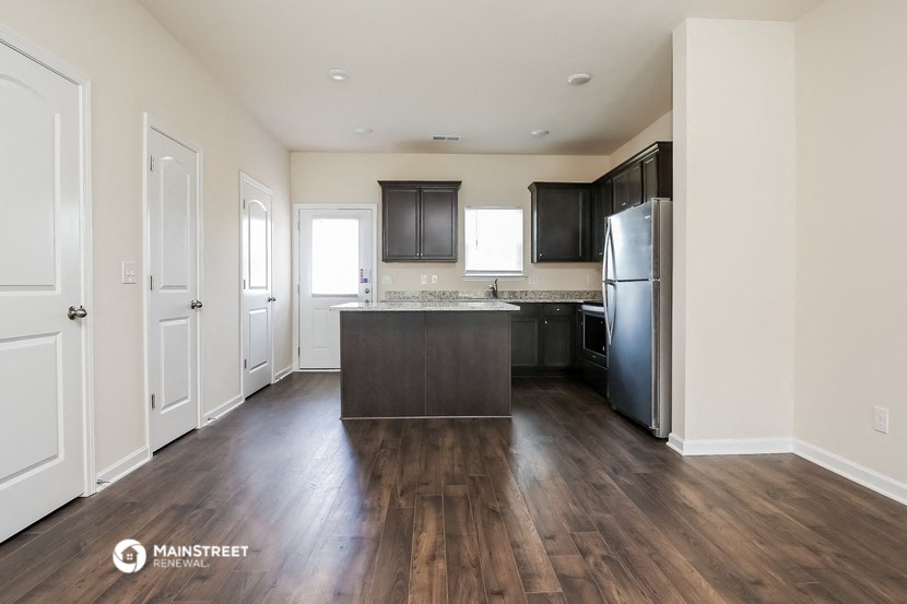 a renovated kitchen with a large island and stainless steel appliances