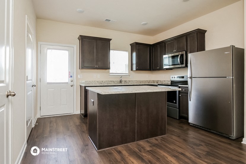 a kitchen with stainless steel appliances and dark wood cabinets