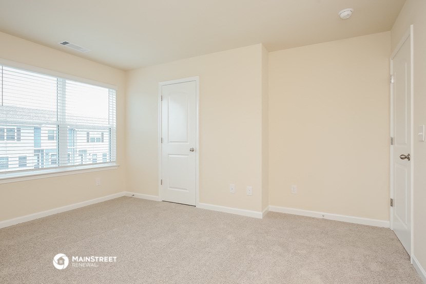 an empty room with a door and a window