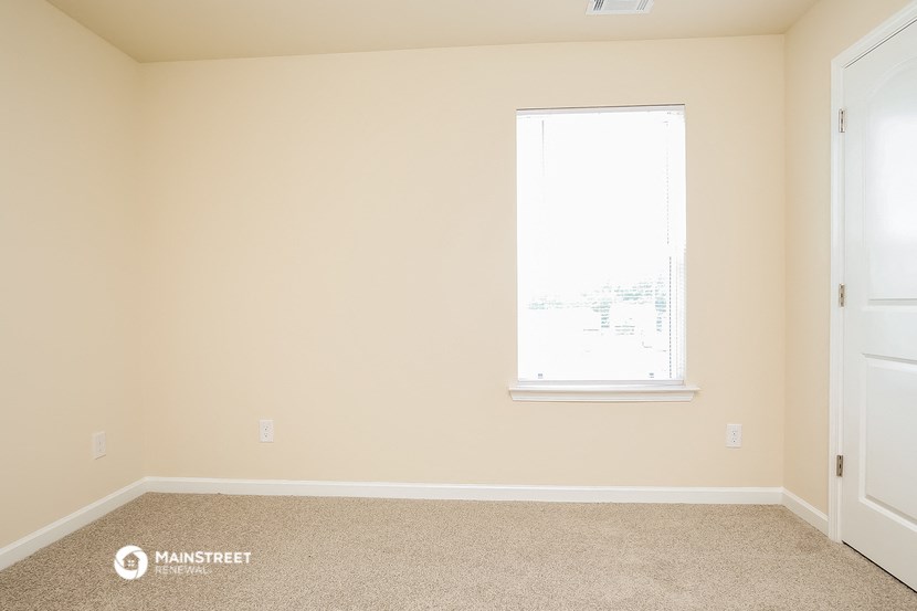 an empty room with a window and a door