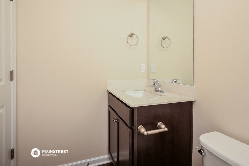 a bathroom with a sink and mirror and a toilet