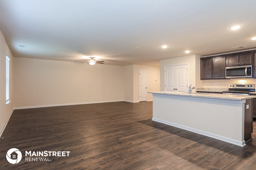 the living room and kitchen of an empty house with a counter top in the middle
