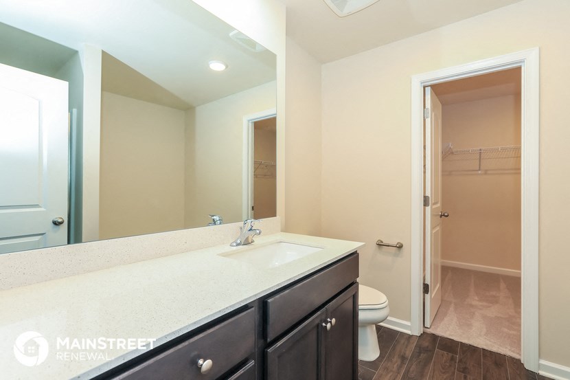 a bathroom with a large mirror and a sink and a toilet