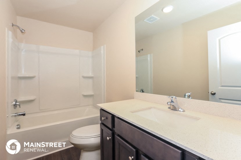 a bathroom with a sink toilet and shower and a mirror