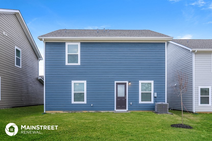 a blue house with a lawn in front of it