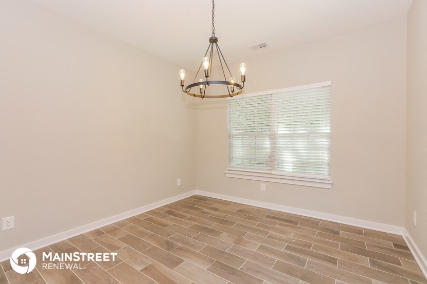 the spacious dining room with a chandelier and tile flooring