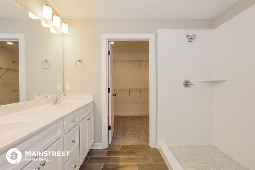 the master bathroom has a large shower and two sinks